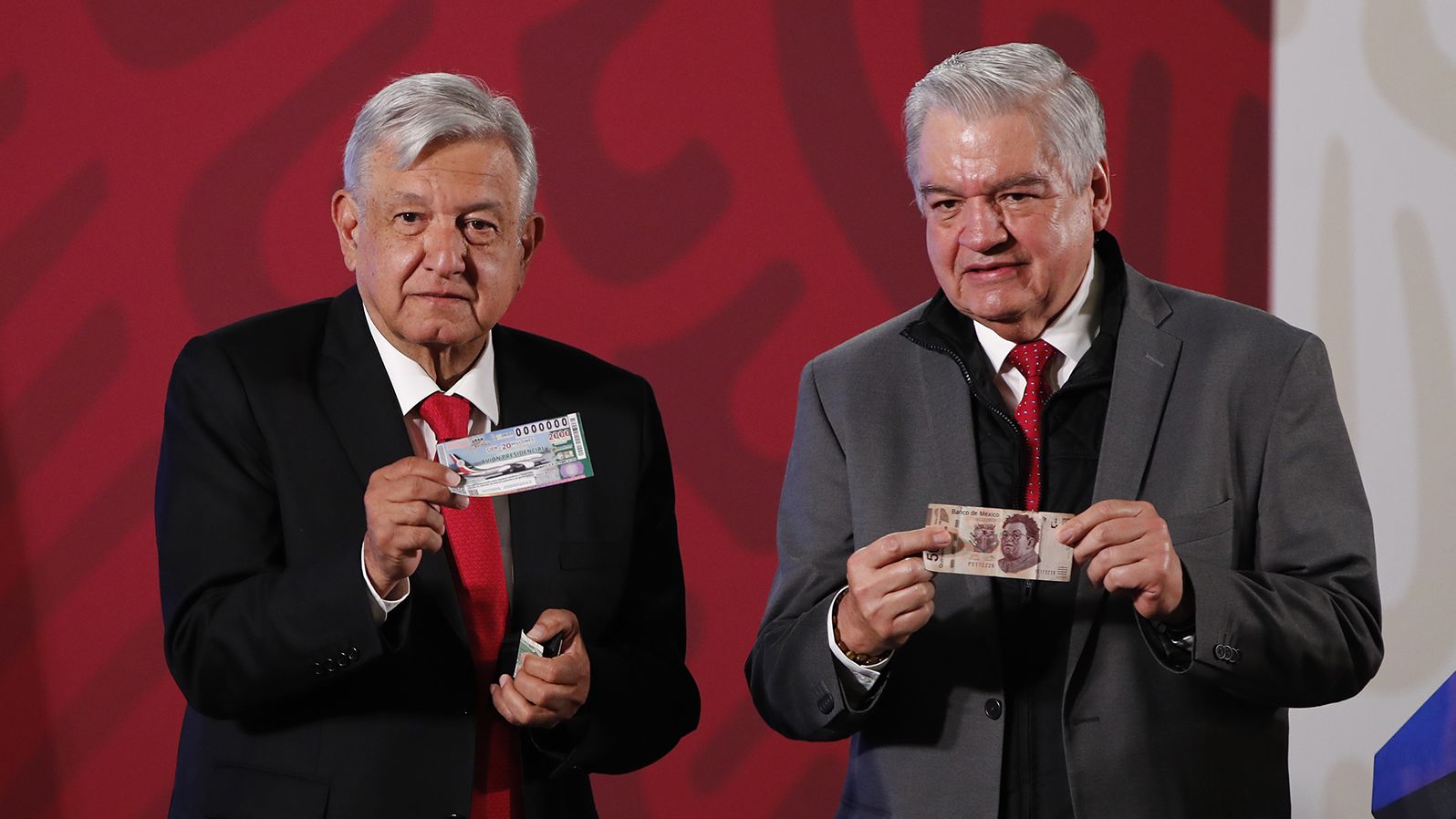 The President of Mexico, Andres Manuel Lopez Obrador, left, shows his ticket for the raffle of the presidential plane next to the general director of the National Lottery, Ernesto Prieto Ortega, on March 3, 2020.