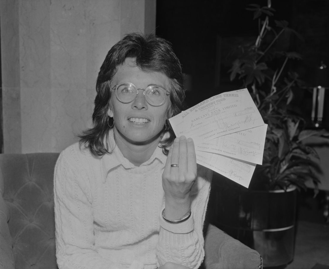 King holds three checks following her win at Wimbledon in 1973.