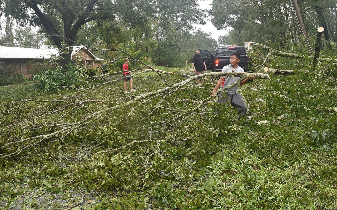 Salvador Hurtado clears trees from a road in Silverhill, Alabama, on September 16.