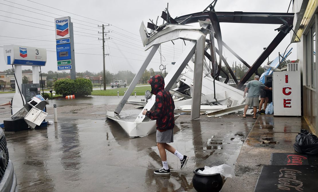People stock up on ice and other items at a damaged convenience store near Spanish Fort, Alabama.