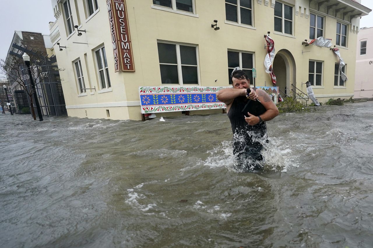 Trent Airhart wades through floodwaters in Pensacola.