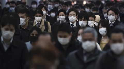 Commuters wearing face masks make their way to work in Tokyo, Japan, on March 26.