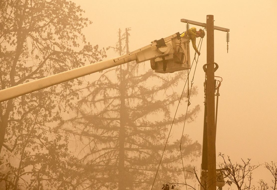 Workers continue to repair the power system after flames from the Beachie Creek Fire burned through Fishermen's Bend Recreation Site in Mill City, Oregon.