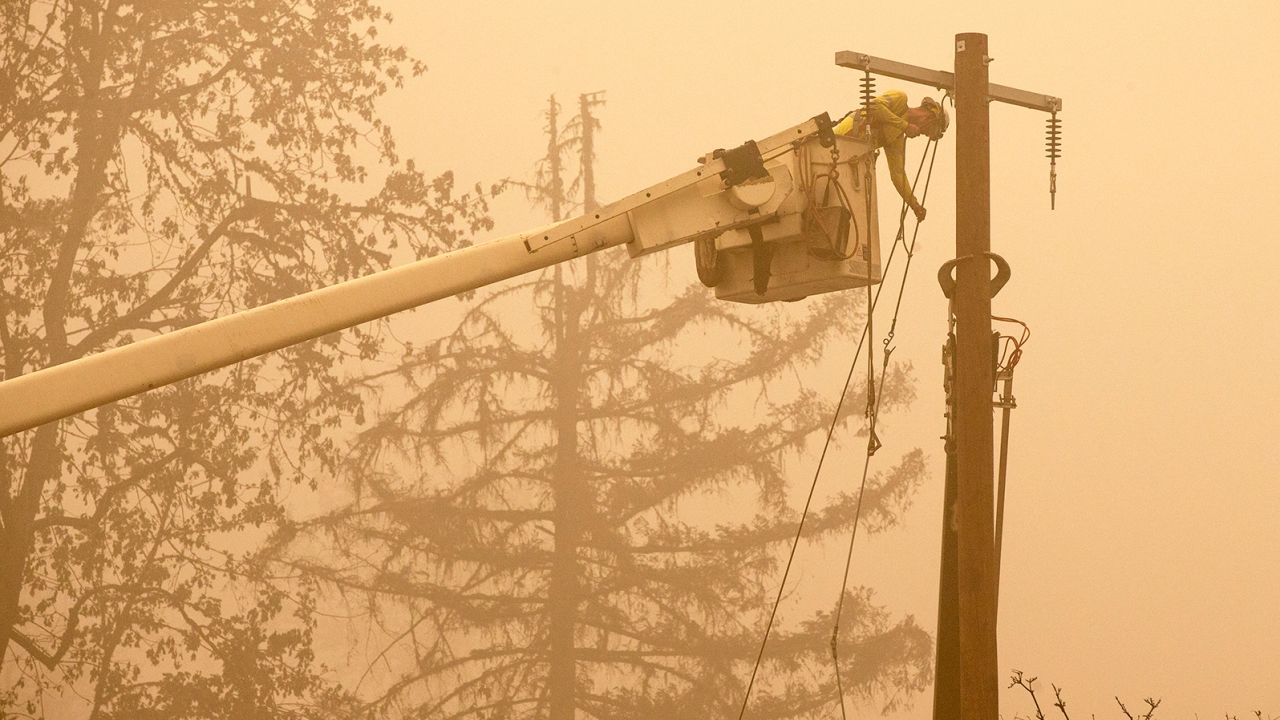 Workers continue to repair the power system after flames from the Beachie Creek Fire burned through Fishermen's Bend Recreation Site in Mill City, Oregon.