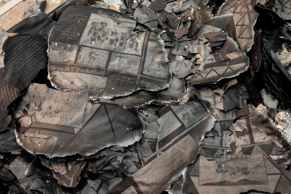 A charred yearbook lies in the debris as Fred Skaff and his son Thomas clean up their home in Phoenix, Oregon, on September 16, 2020.