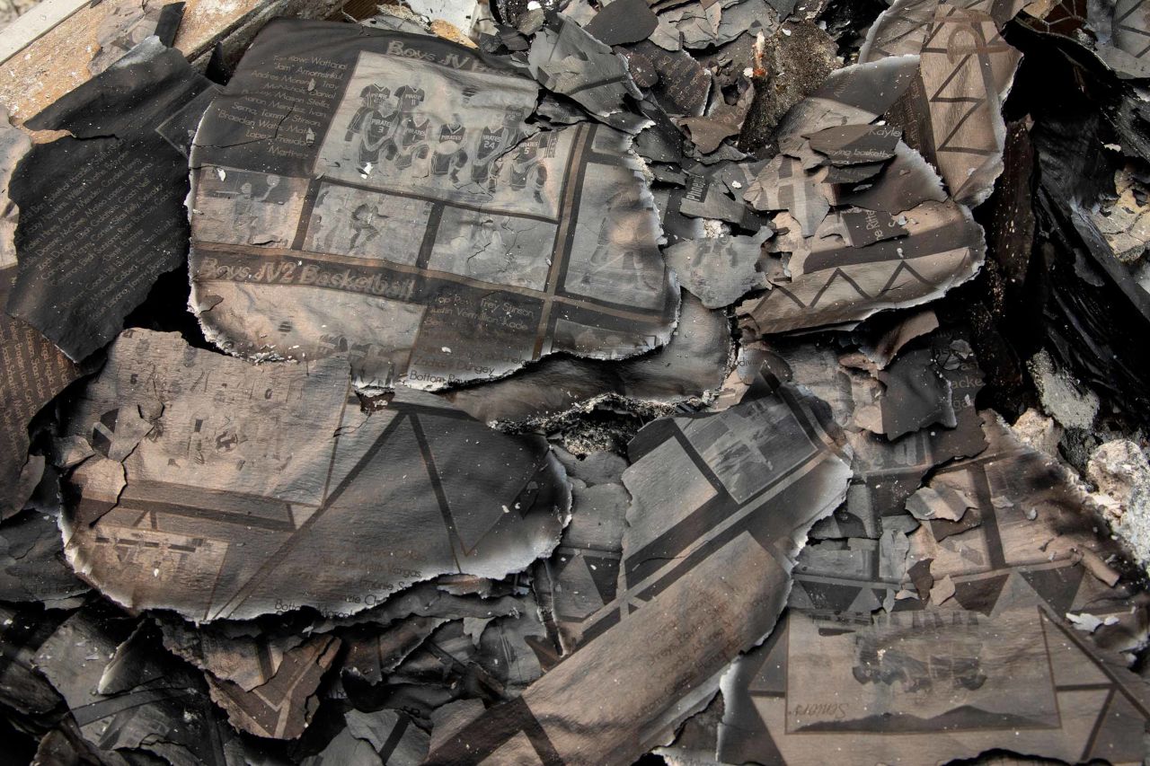 A charred yearbook lies in the debris as Fred Skaff and his son Thomas clean up their home in Phoenix, Oregon, on September 16.