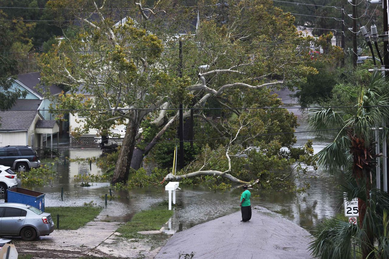 A person views a flooded neighborhood in Pensacola after Hurricane Sally passed through the area.