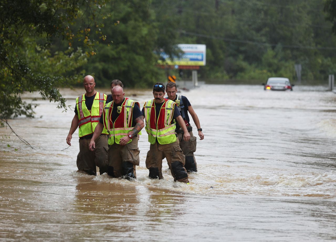 Members of the Pace Fire Rescue department wade through a flooded road in Pensacola.