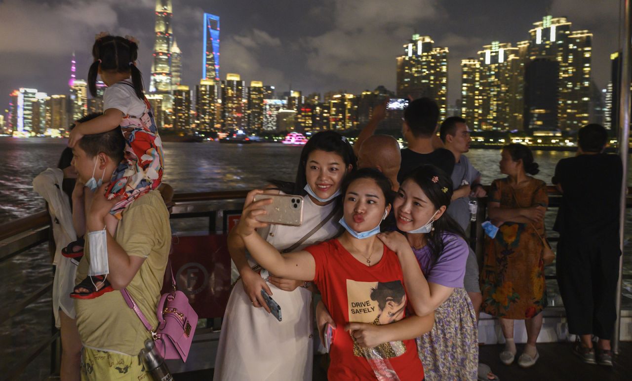 Tourists pose for photos on September 1 in Shanghai. As Chinese stay home, domestic tourism is thriving. 