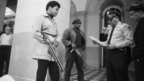 Two members of the Black Panther Party are met on the steps of the State Capitol in Sacramento, California, on May 2, 1967. Police Lt. Ernest Holloway informed them they would be allowed to keep their weapons as long as they caused no trouble.
