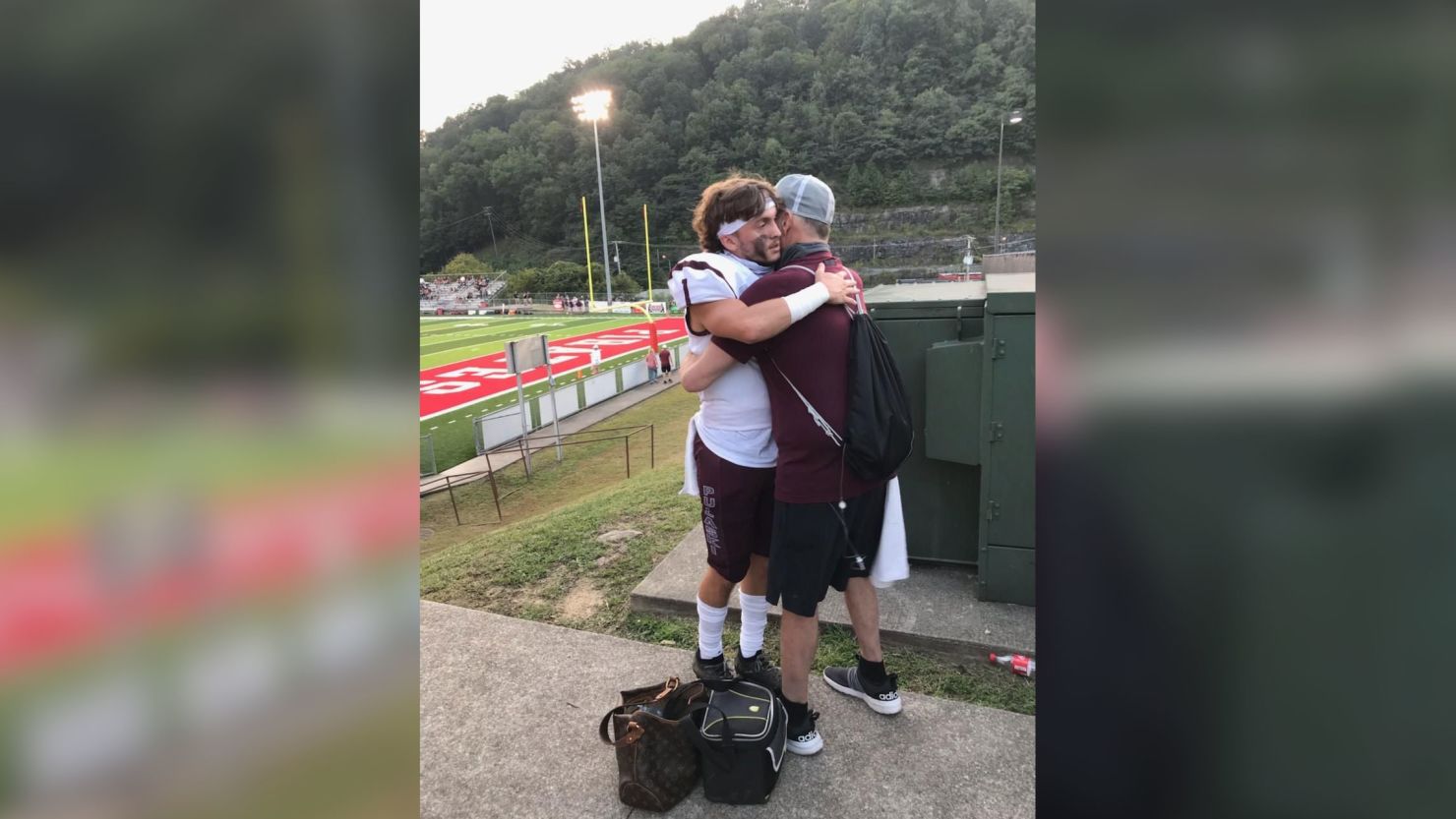 Scott Sullivan, terminally ill with cancer, hugs his son Cade before the opening game of high school football season.