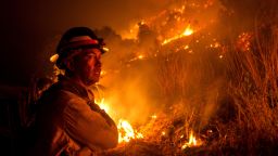 A firefighter watches the Bobcat Fire burning on hillsides near Monrovia Canyon Park in Monrovia, California on September 15, 2020. (Photo by Ringo Chiu/AFP/Getty Images)