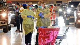 Bismarck-Burleigh Public Health nurses Crys Kuntz, left, and Sara Nelson confer inside the Bismarck Event Center on Tuesday, Sept. 8, 2020, in Bismarck, N.D., where vehicles were lined up for the weekly drive-thru COVID-19 testing. Coronavirus infections in the Dakotas are growing faster than anywhere else in the nation, fueling impassioned debates over masks, personal responsibility and freedom after months in which the two states avoided the worst of the pandemic. (Tom Stromme/The Bismarck Tribune via AP)