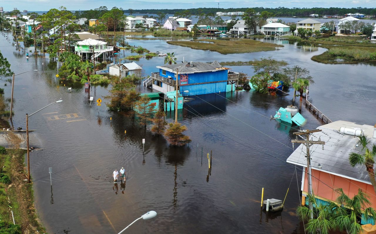 People walk through a flooded street in Gulf Shores, Alabama, on September 17.