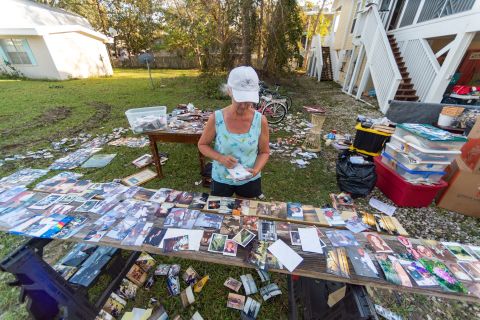 Yolanda Johnson lays out photos to dry after Sally flooded her home in Orange Beach, Alabama.