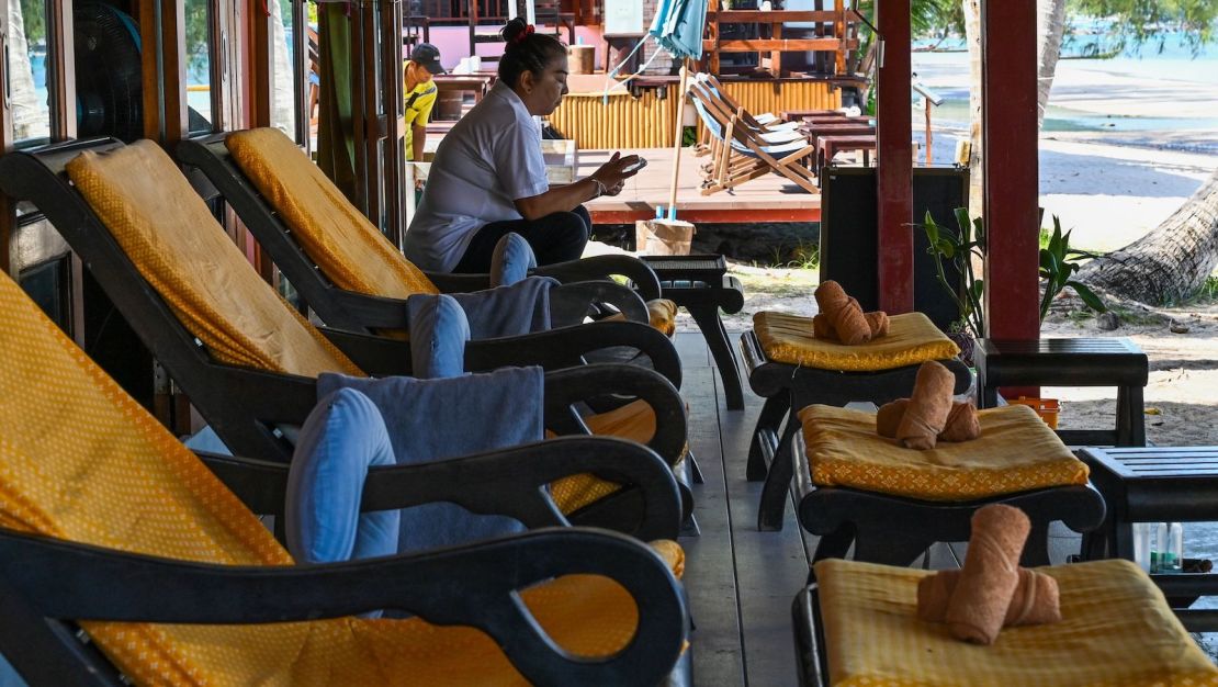 A masseuse waits for customers at an empty massage parlor on Koh Tao, a popular Thai island, on August 21.