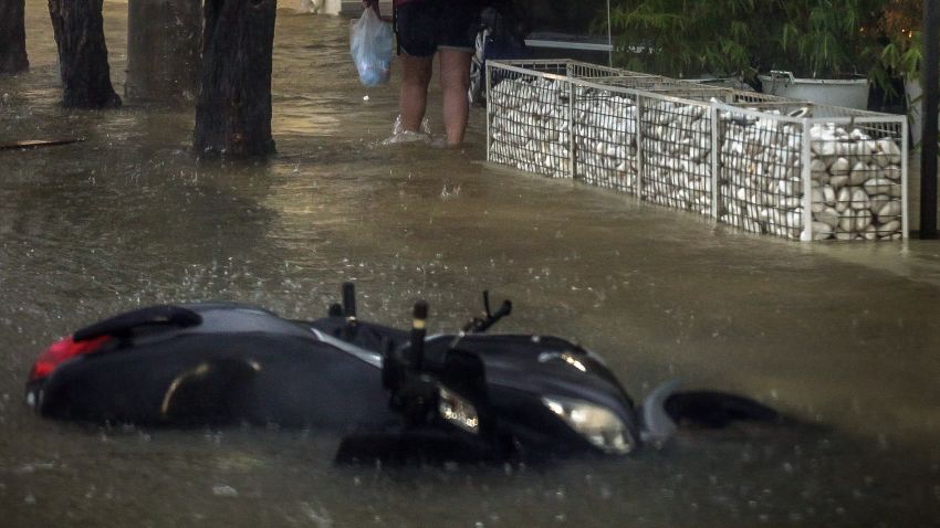 A man walks into a flooded road during a storm at the port of Argostoli, on the Ionian island of Kefalonia, western Greece, Friday, Sept. 18, 2020. A powerful tropical-like storm named Ianos battered the western islands of Zakynthos, Kefalonia, and Ithaki overnight, causing flash flooding, property damage, power outages, and road closures mostly from downed trees, police and local authorities said. (AP Photo/Nikiforos Stamenis)