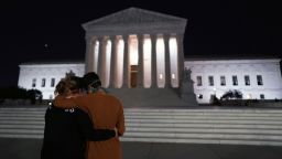 Two women embrace in front of the Supreme Court buidling paying their respects to Justice Ruth Bather Ginsburg after she died, in Washington, DC, on September 18, 2020. 