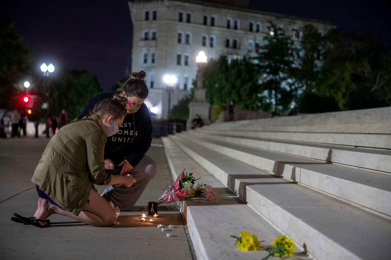 Two women light a candle at the steps of the Supreme Court on September 18.