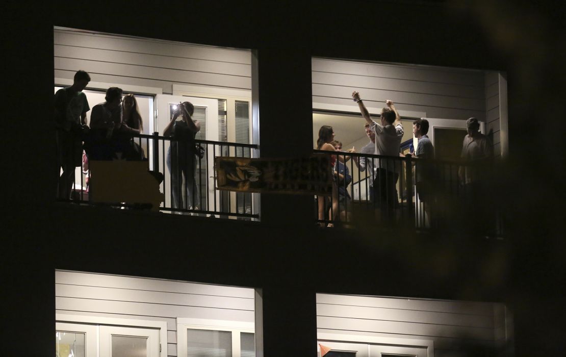 Partiers congregate on the balcony of a downtown apartment in Columbia, Mo., near the University of Missouri campus.