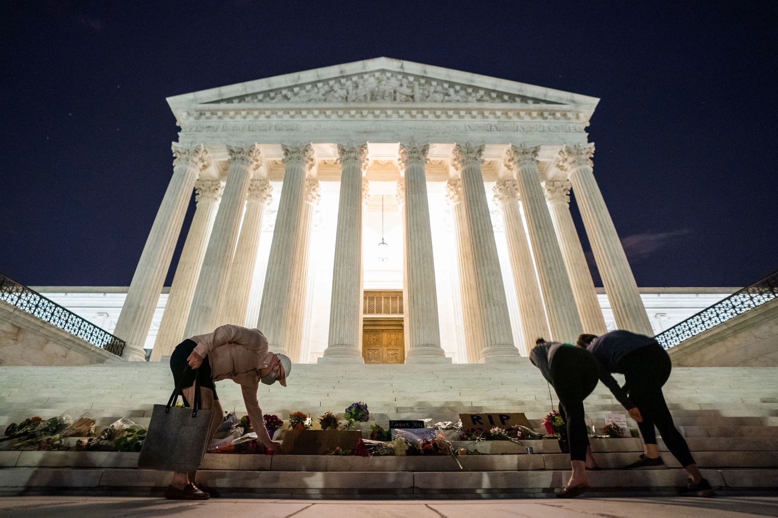 Mourners place flowers and notes of condolences outside of the Supreme Court.