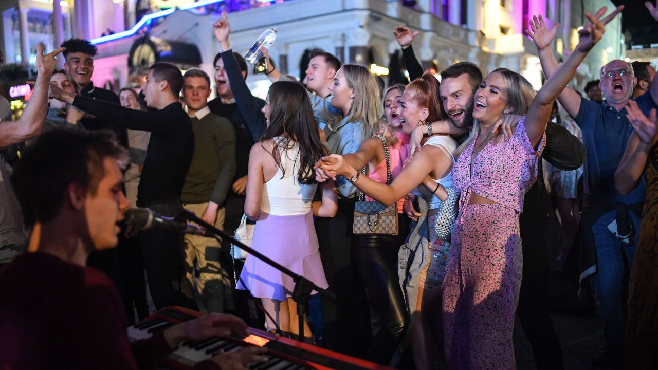 People are seen dancing to a busker in Leicester Square, central London, on September 12, days before social gatherings were restricted again.