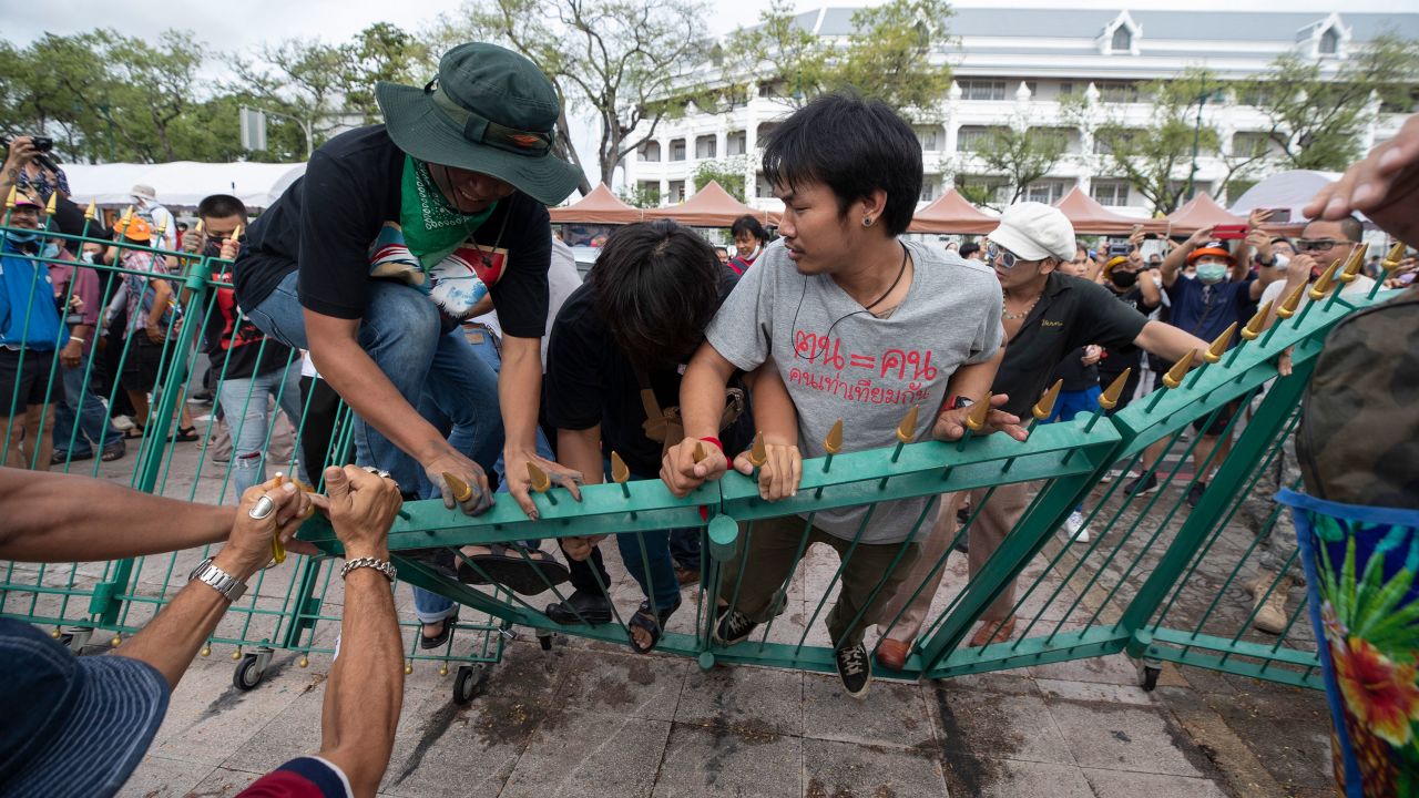 Pro-democracy protesters push over a fence surrounding the  Sanam Luang field during a protest in Bangkok, Thailand, on September 19.