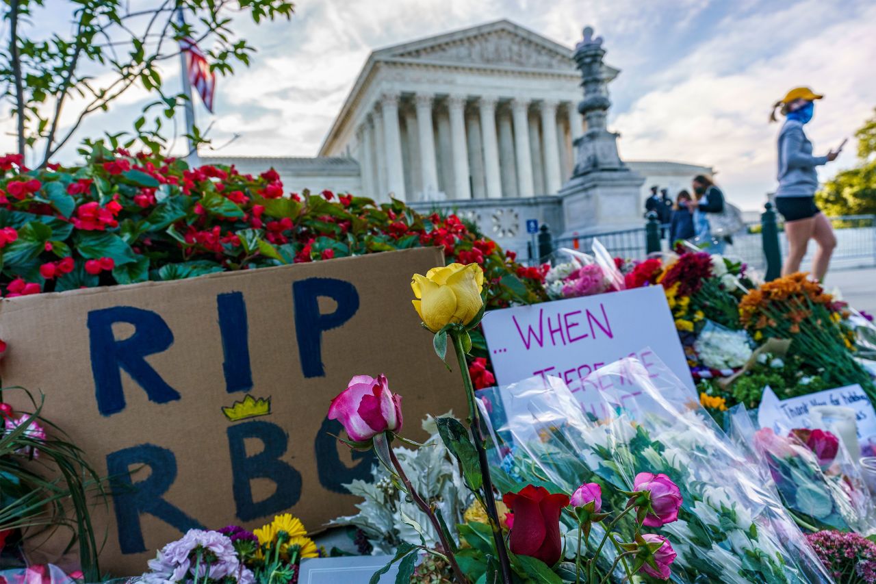Flowers are left at the makeshift memorial in front of the Supreme Court.