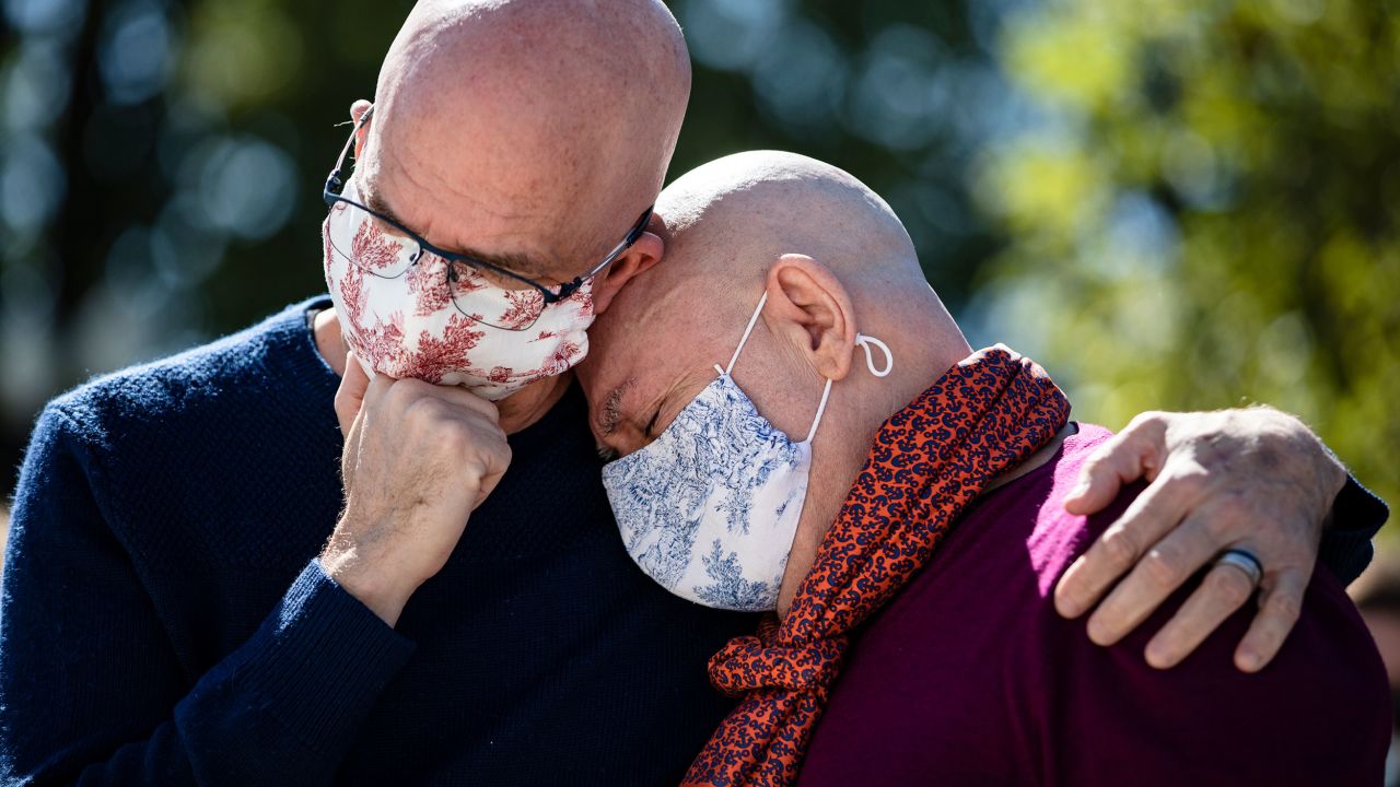 Michael Widomski, left, and David Hagedorn embrace in front of the US Supreme Court on Sunday, September 20. They had just left a photo of Ginsburg, joining them in marriage, at Ginsburg's makeshift memorial. Ginsburg officiated their wedding in 2013, two years before the Supreme Court cleared the way for same-sex marriages around the country.