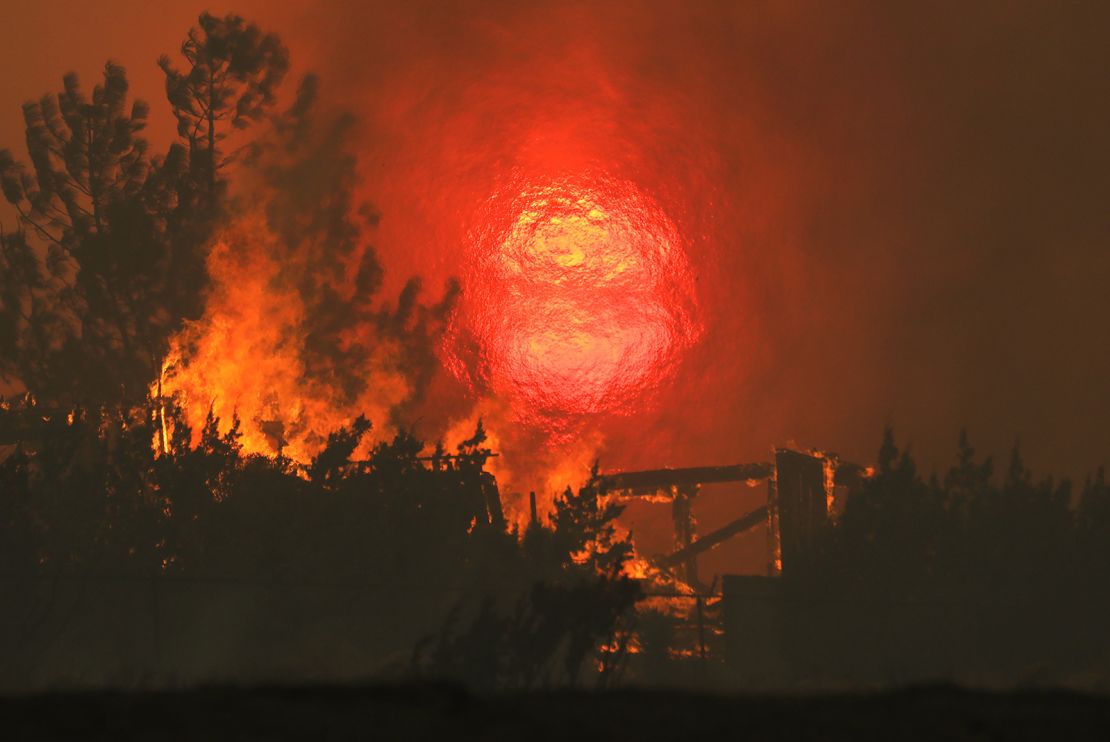  A home burns as the sun sets behind smoke and flames during the Bobcat Fire in Juniper Hills, California. 
