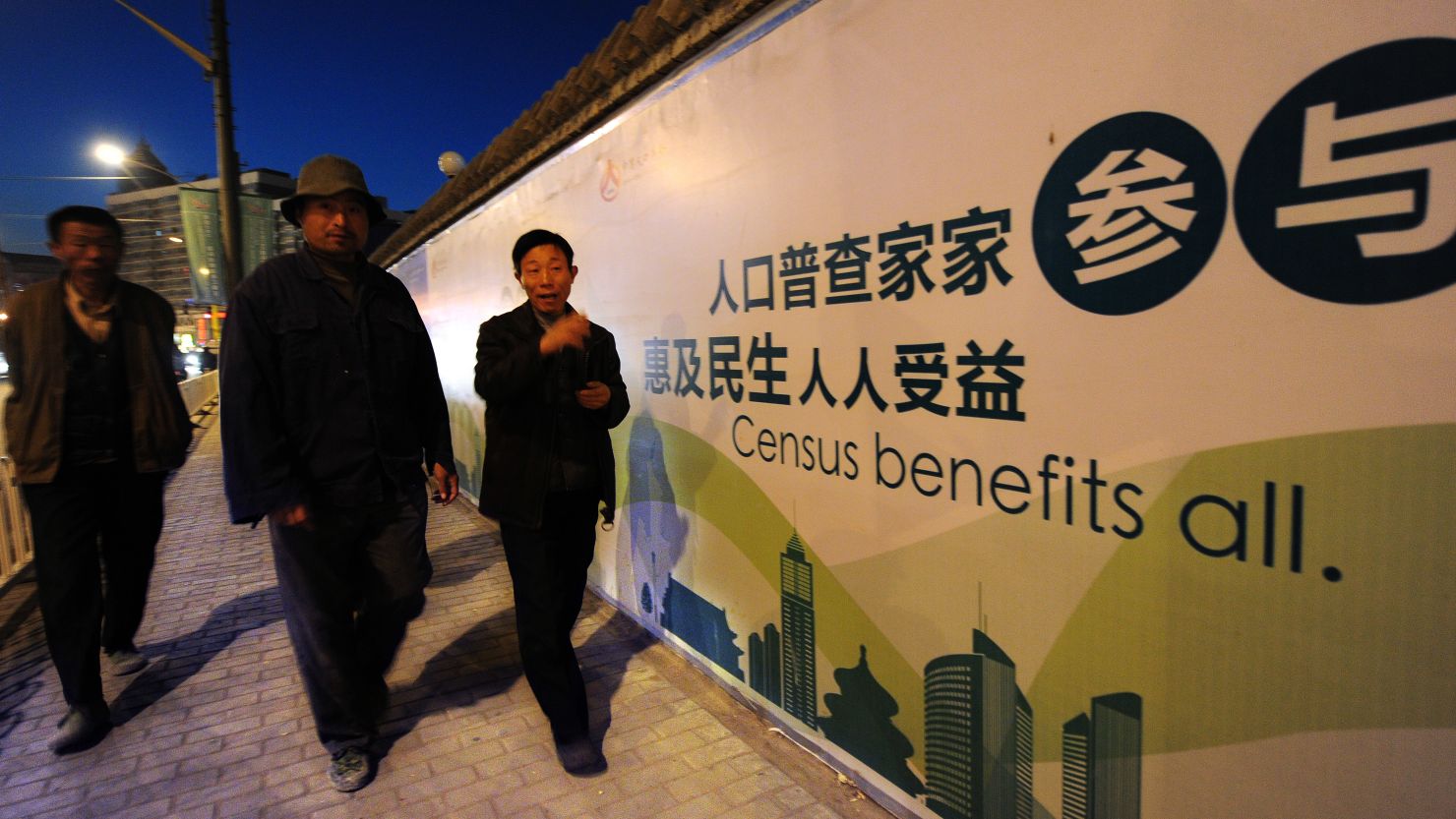 Pedestrians walk past a billboard for China's last national population census on October 29, 2010 in Beijing.