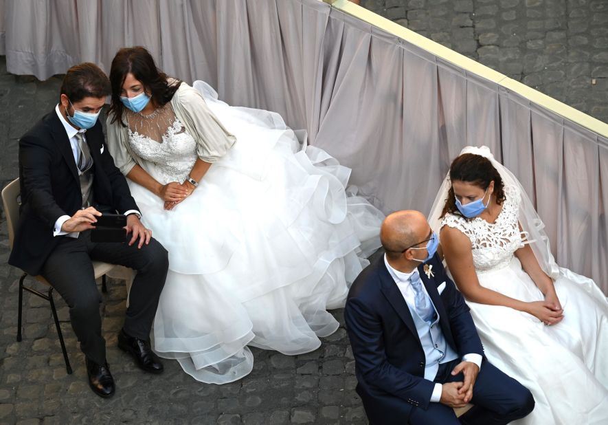 Brides and grooms wait for the Pope's arrival at the San Damaso courtyard in the Vatican on September 16.