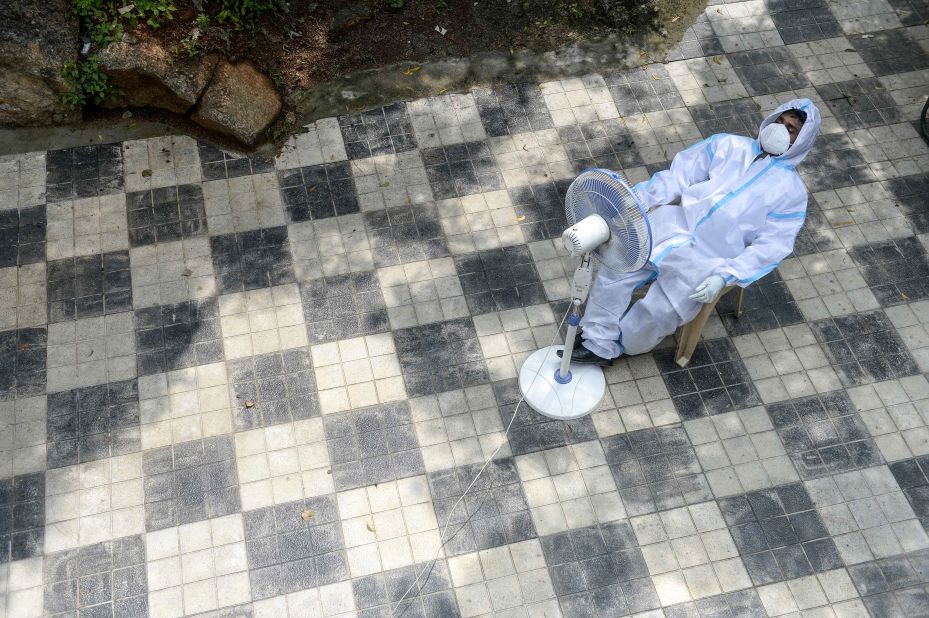 A health worker in Hyderabad, India, takes a break in front of a fan on September 17.