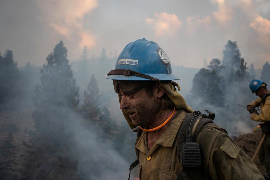 Firefighter Kirk McDusky walks past smoke rising from the Brattain Fire in Paisley, Oregon, on September 18, 2020.