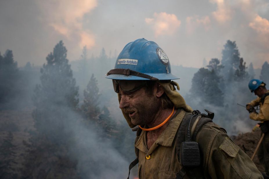 Firefighter Kirk McDusky walks past smoke rising from the Brattain Fire in Paisley, Oregon, on September 18, 2020. 