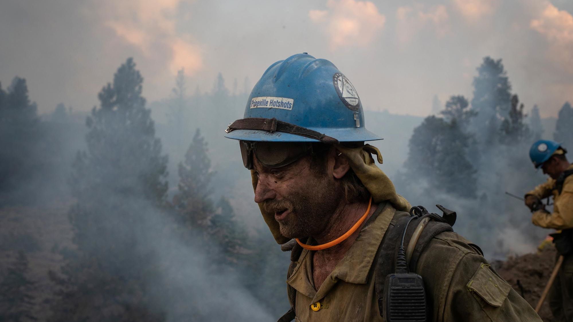 Firefighter Kirk McDusky walks past smoke rising from the Brattain Fire in Paisley, Oregon, on September 18, 2020. 