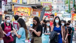 People wearing protective masks walk past food stalls at the Ningxia Night Market in Taipei, Taiwan, on Thursday, July 30, 2020. As the world braces for the worst economic contraction since since World War II, Taiwan appears poised to get away lightly. Economists expect the export-dependent island to show a second-quarter performance that is merely stagnant, as opposed to the deep recessions seen elsewhere, and a brighter outlook for the rest of the year. Photographer: I-Hwa Cheng/Bloomberg via Getty Images