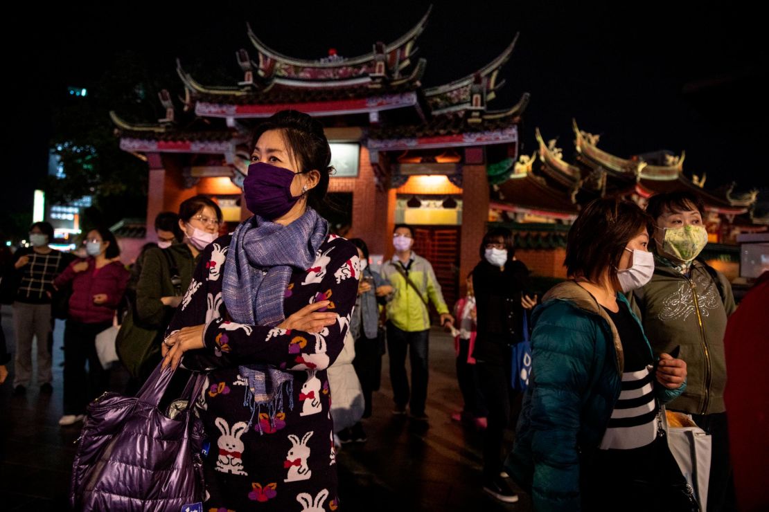 Residents stand outside Hsing Tian Kong temple on March 17, 2020 in Taipei, Taiwan.