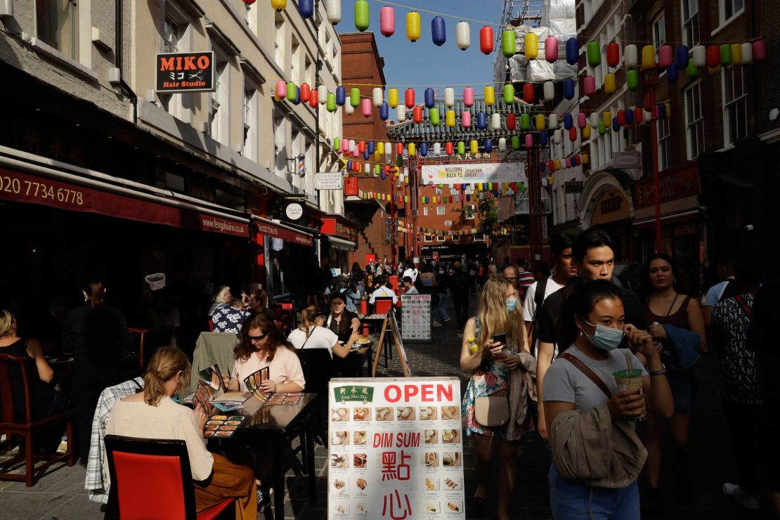 People sit outside in Chinatown, central London, on Saturday. The UK has introduced a 10 p.m. curfew for pubs and restaurants.