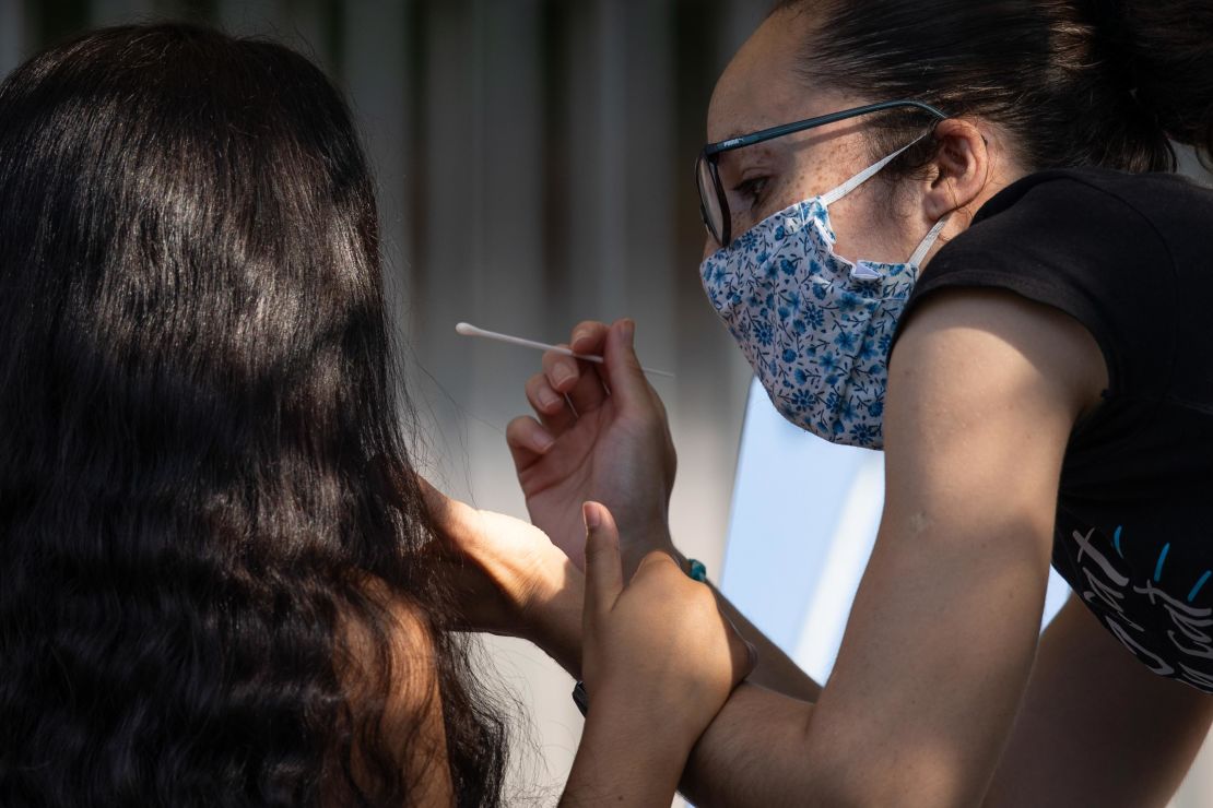 A woman administers a swab test to a girl at a Covid test site in London, England, on September 15.