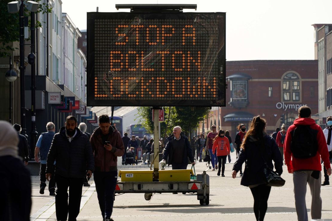 People walk past an electronic sign in Bolton, England, on September 17. 