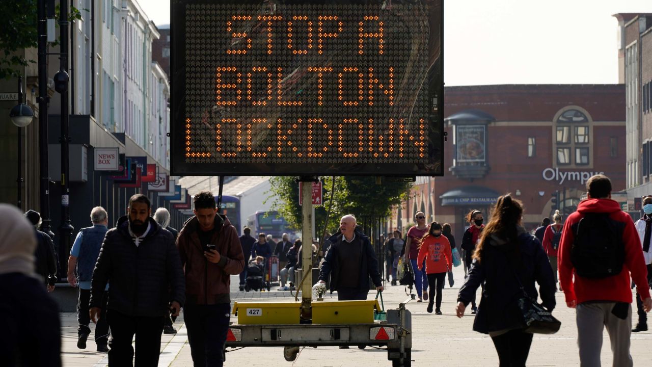 People walk past an electronic sign in Bolton, England, on September 17.