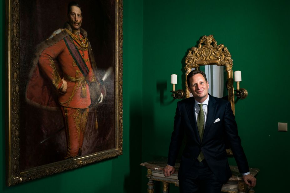 Georg Friedrich, Prince of Prussia at the Hohenzollern Castle, beside a painting of his ancestor William II, the last Kaiser of Germany.