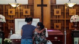 Los Angeles, CA, August 5, 2020 - 40-year-old Iris Martinez weeps as she stands three-feet from her fathers casket. Daddy! she cries out, while her best friend, Grace Salgado comforts her. In the casket, is Rafael Martinez, who was 60 when he died.  In the throes of the Covid-19 epidemic Continental Funeral Home struggles to keep up with the demands of rising death rates in a community suffering with health and finances. (Robert Gauthier / Los Angeles Times via Getty Images)