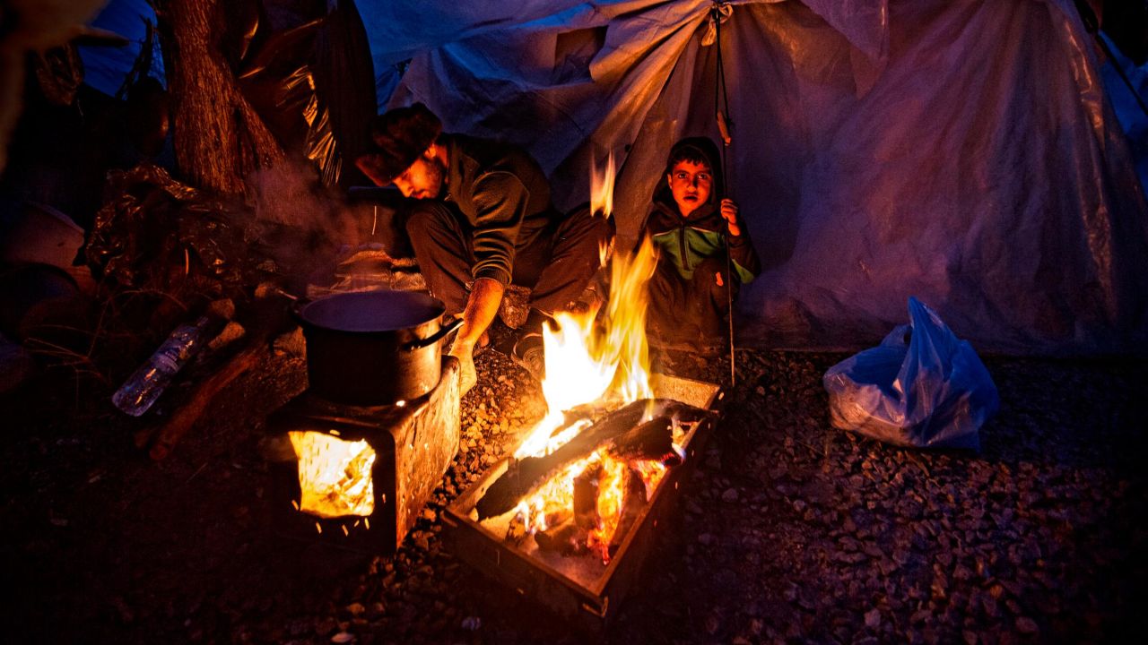 People gather around a fire for warmth in the Moria refugee camp in Lesbos, Greece in February 2020.