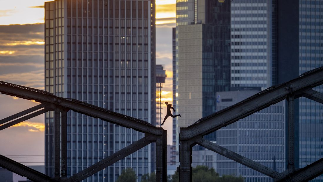 <strong>Frankfurt, Germany:</strong> A parkour runner jumps on a railway bridge with the buildings of the banking district as a backdrop. <br />