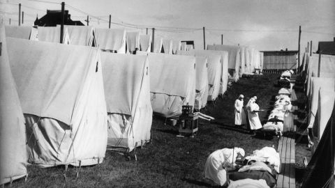 1918: Nurses care for victims of an influenza epidemic outdoors amid canvas tents in Lawrence, Massachusetts. 