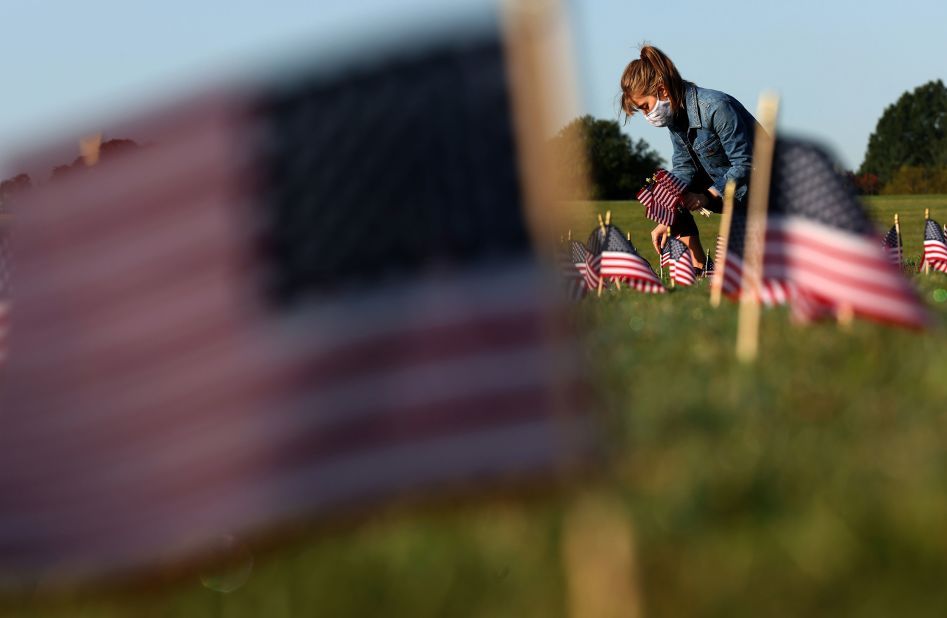 Carmen Wilke places flags September 22 as part of the Covid Memorial Project, which installed 20,000 American flags on the National Mall in Washington, DC. <a href="index.php?page=&url=https%3A%2F%2Fwww.cnn.com%2Finteractive%2F2020%2Fhealth%2Fcoronavirus-us-maps-and-cases%2F" target="_blank">More than 200,000 people in the United States have died</a> from Covid-19.