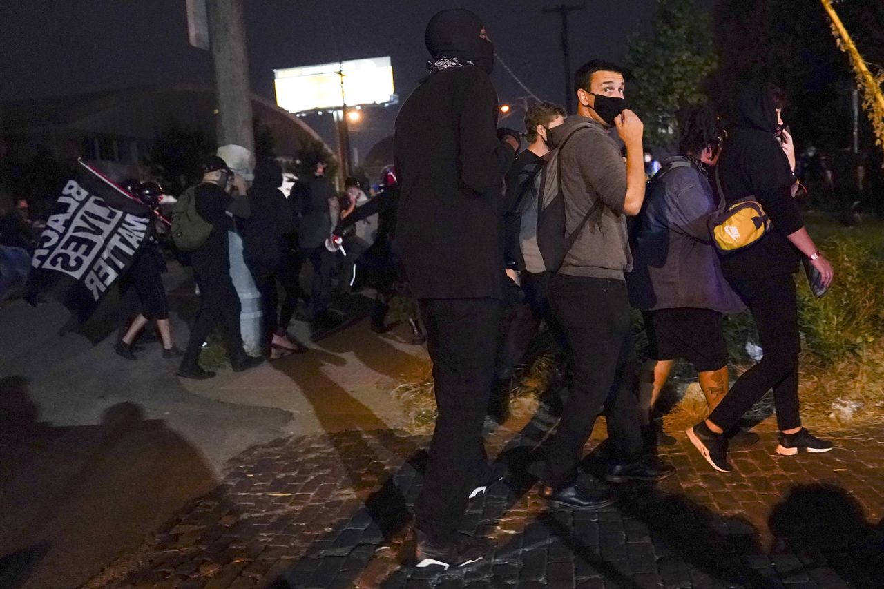 Demonstrators in Louisville react to gunfire. Two officers with the Louisville Metro Police Department were shot Wednesday night during the protests.