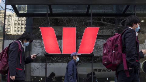 Pedestrians wearing protective face masks walk past the Westpac Banking Corp. 